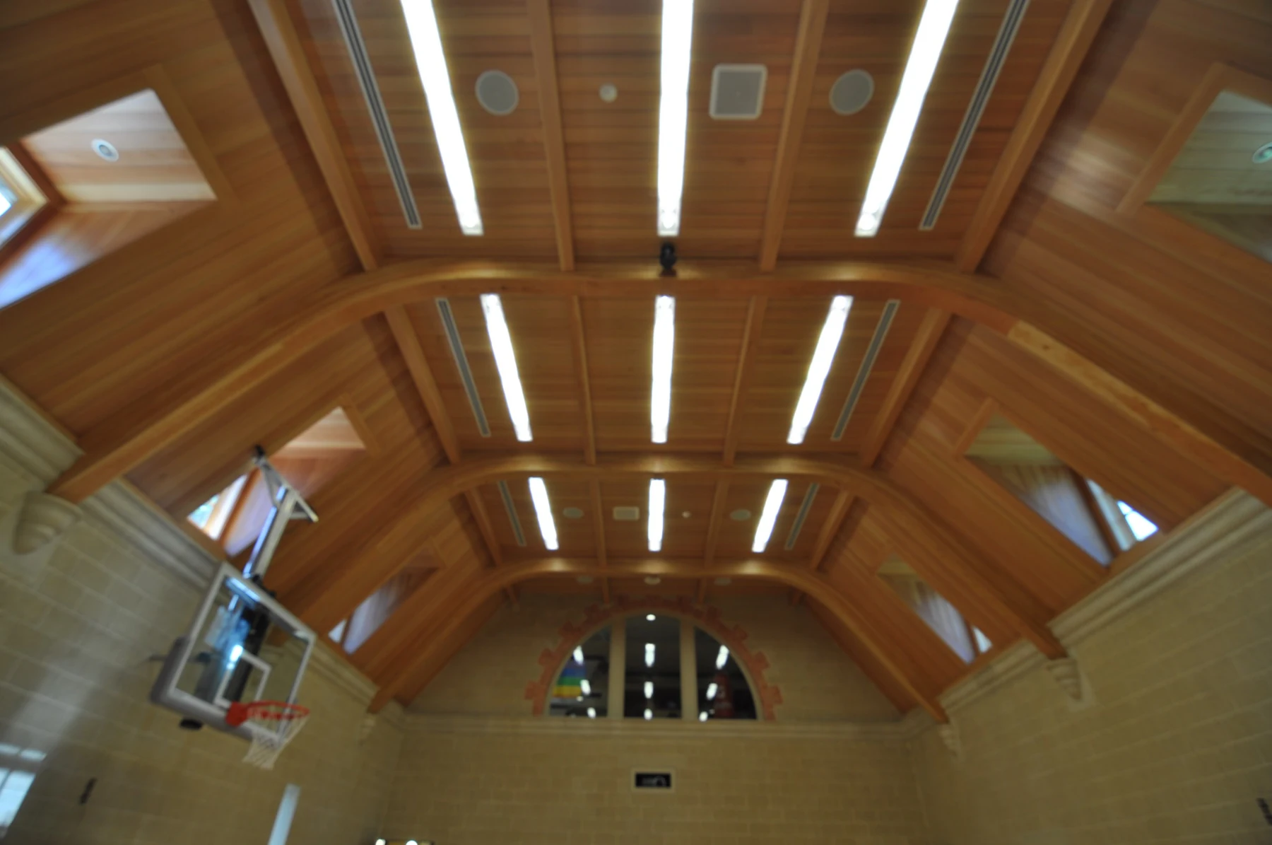 Euclid Ave gym showing custom luminaires across the wood ceiling